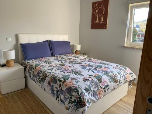 una camera da letto con un letto con copriletto floreale di Maison Cosy et Moderne a Vila Real