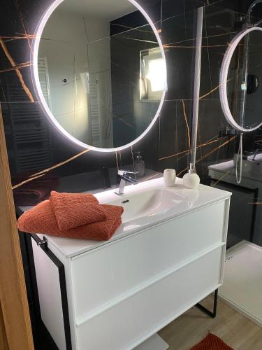 a bathroom with a white sink and a mirror at Maison Cosy et Moderne in Vila Real