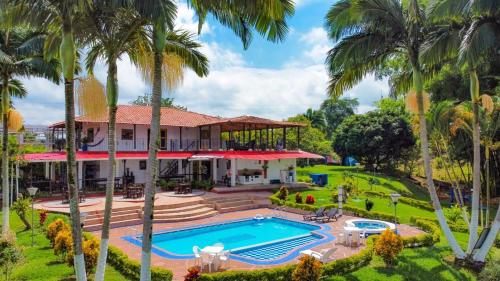 an aerial view of a house with a swimming pool and palm trees at Finca Hotel Andaquies in Armenia