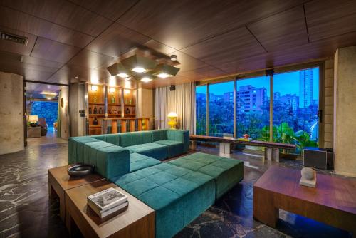 a living room with a green couch and large windows at 23 Living in Medellín