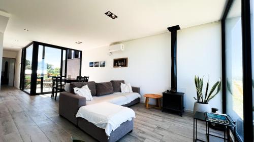 a living room with a couch and a table at Casa Altamar - Casa Con Vista Al Mar en Playa Cruz del Sur, Chapadmalal Para 6 PAX Con Parrilla y Cochera - Hola Sur in Chapadmalal