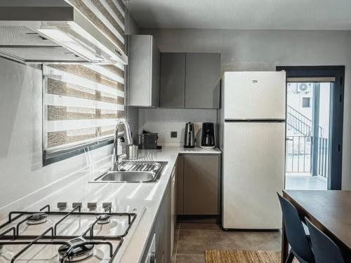 Una cocina con un refrigerador blanco y una mesa. en Bodrum marina, en Bodrum City