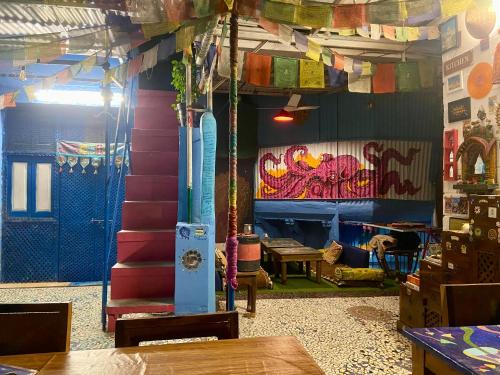 une pièce aux murs colorés et un escalier avec une table dans l'établissement Bob hostel, à Jodhpur