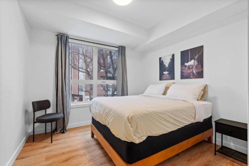 a bedroom with a bed and a window at Luxurious Large 3 Bedroom Loft Saskatchewan Drive in Edmonton