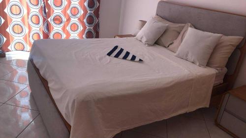 a bed with a black and white blanket on it at Condominio atlantico ll in Praia