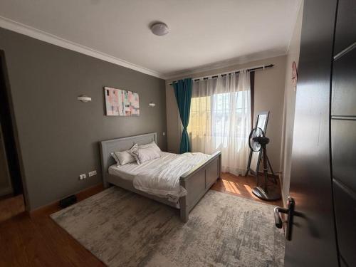 a bedroom with a bed and a window at Ariette Homes in Buwate