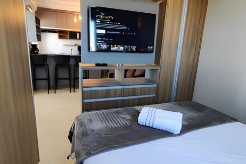 a bedroom with a bed and a flat screen tv at Aeroporto Gru, Ar Condicionado, Piscina+Academia 7 in Guarulhos