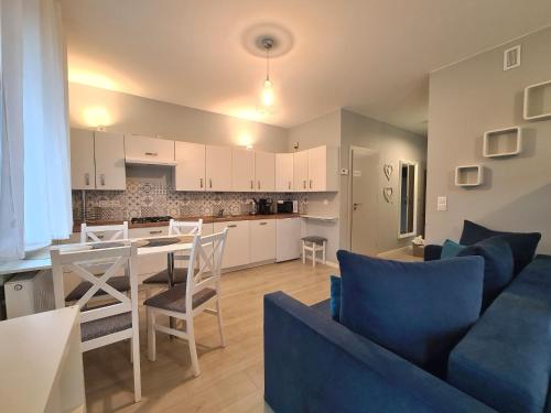 a living room and kitchen with a table and chairs at APARTAMENTY "LA VILLA" SUPERIOR III na parterze z prywatnym ogrodem, tarasem, parkingiem, blisko centrum, spokojna okolica in Kudowa-Zdrój