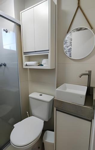 a bathroom with a toilet and a sink and a mirror at Aeroporto Gru, Ar Condicionado, Piscina+Academia 7 in Guarulhos