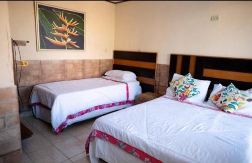 Giường trong phòng chung tại Pousada Bougain Ville Para-tí