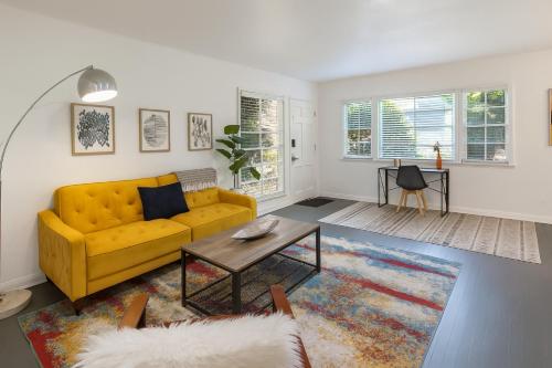 a living room with a yellow couch and a table at Quaint 1BD 1BA Bungalow in Los Angeles