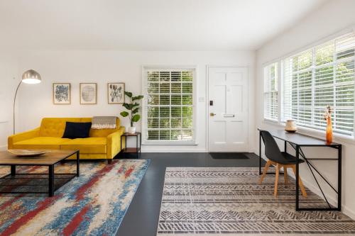 a living room with a yellow couch and a table at Quaint 1BD 1BA Bungalow in Los Angeles
