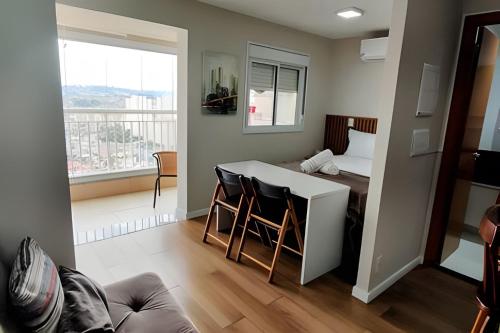 a room with a bed and a table and chairs at Aeroporto GRU e Shopping Maia, com Ar Condicionado in Guarulhos