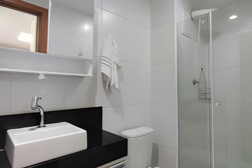 a white bathroom with a sink and a shower at Aeroporto GRU e Shopping Maia, com Ar Condicionado in Guarulhos