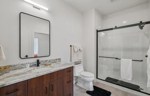 a bathroom with a shower and a toilet and a sink at Modern Downtown Detroit 2BR Retreat in Detroit