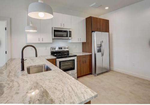 a kitchen with a sink and a stainless steel refrigerator at Modern Downtown Detroit 2BR Retreat in Detroit