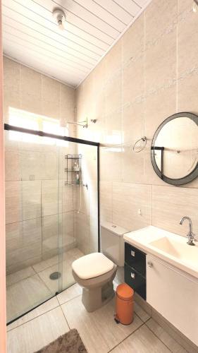 a bathroom with a shower and a toilet and a sink at Pousada da Lua Barretos in Barretos