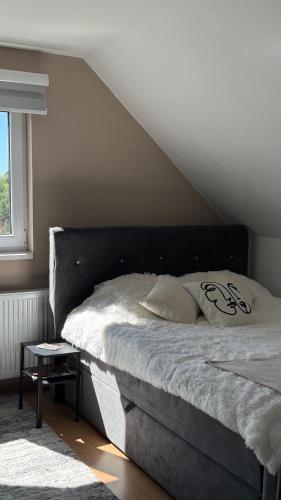 a bed with a black headboard in a bedroom at Apartman Ilić in Divčibare