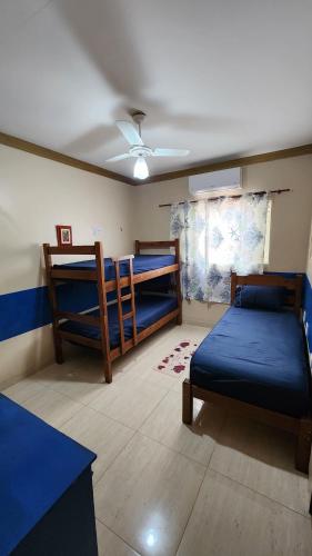 a room with two bunk beds and a table at Pousada da Lua Barretos in Barretos