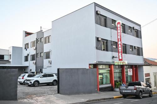 Hotel Bandeirantes de SJBV في ساو جواو دا بوا فيستا: موقف سيارات به سيارات متوقفة أمام مبنى