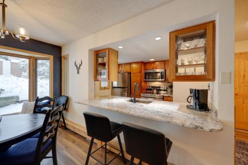 a kitchen and dining room with a table and chairs at Charming Vail Condo with Patio and Mountain Views in Vail