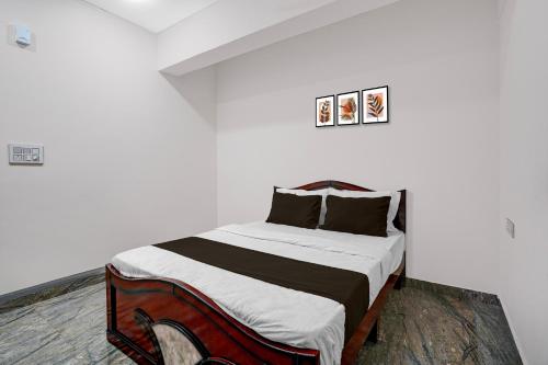 a bedroom with a bed in a white room at Hotel O Bhuvika Residency in Jālahalli