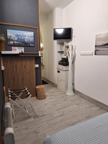 una habitación con una mesa y una silla y un televisor en Portico 32 - Merano centro, en Merano