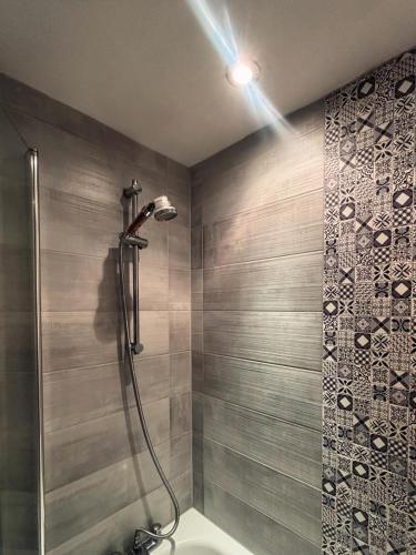 a bathroom with a shower with a shower head at Fairy Cove Cottage in Paignton