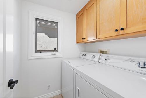 eine Küche mit Waschmaschine und Fenster in der Unterkunft Laguna Beach Coastal Cottage in Laguna Beach