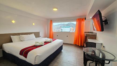 Hotel Cusco Museo في كوسكو: غرفة نوم بها سرير وطاولة ونافذة