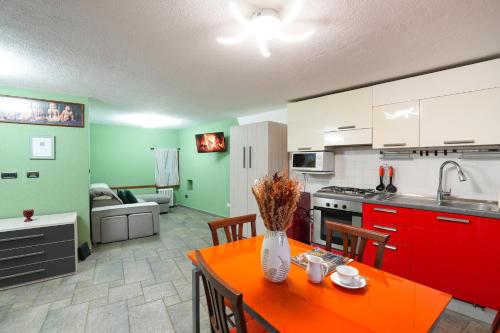 una cucina con un tavolo arancione in una stanza di Roisan Apartment a Castello