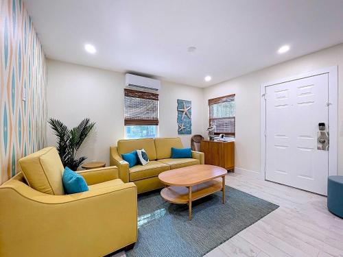 a living room with a yellow couch and a table at Reel Paradise steps to bay beach fishing dock in Bradenton Beach