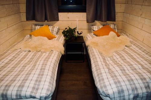 twee eenpersoonsbedden in een kamer met een tafel bij Luxury Arctic Cabin in Øverbygd