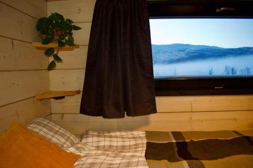 een slaapkamer met een raam met uitzicht op een berg bij Luxury Arctic Cabin in Øverbygd