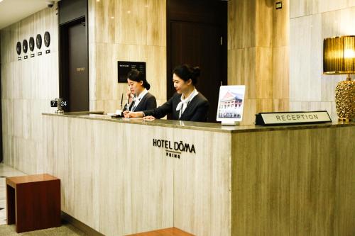 two women sitting at a reception desk in a lobby at Hotel Doma Myeongdong in Seoul