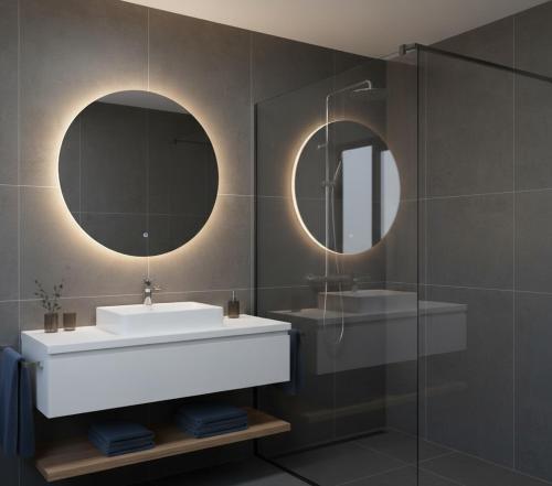 a bathroom with a sink and two mirrors at Hotel Clina in Adana
