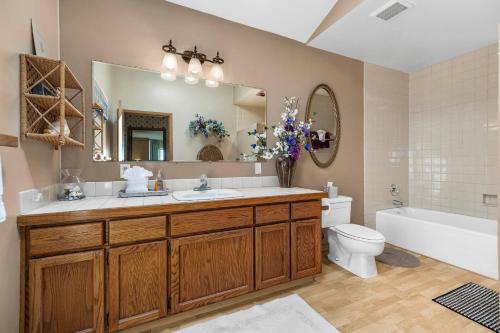 ein Badezimmer mit Waschbecken, Toilette und Spiegel in der Unterkunft Fantastic Beach View! Oregon Escape with Game Room in Seaside