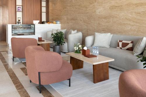 a living room with a couch and a table and chairs at فندق رويال اديشن للشقق الفندقية in Buraydah