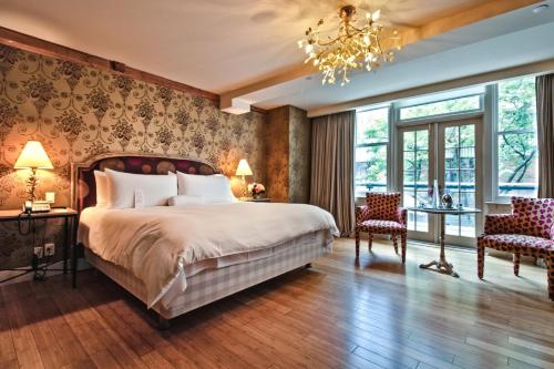 トロントにあるジ アイビー アット ベリティのベッドとシャンデリアのある寝室