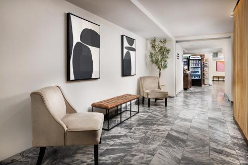 a hallway with chairs and a table and paintings at The Shoreham in New York