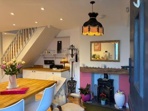 a kitchen with a dining table and a staircase at Half Pint Cottage in Uplyme