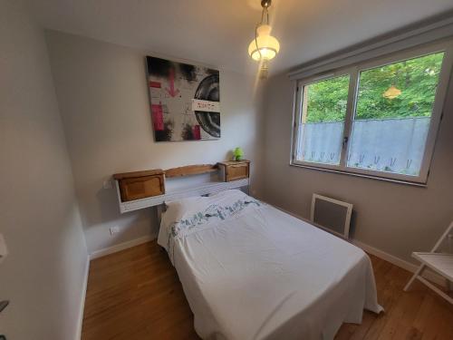 una camera da letto con un letto bianco e una finestra di Chalet Claree a Val des Pres a Le Rosier