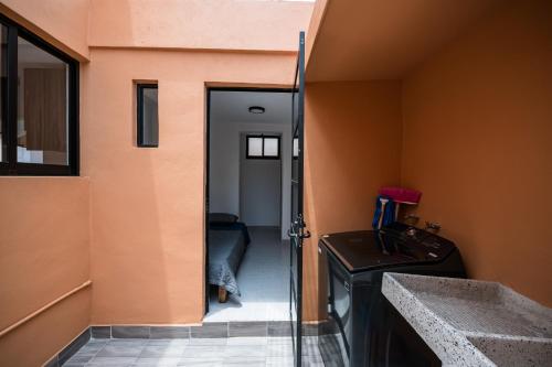 a bathroom with a sink and a door to a hallway at Residencias Santa Rosa de Viterbo 68 in Casa Blanca La Corregidora