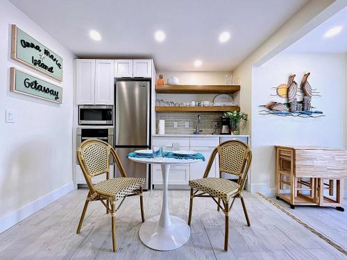 a kitchen with a table and two chairs and a refrigerator at Paradise Cove at Island Getaway in Bradenton Beach