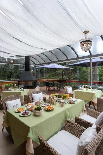 een eetgedeelte met tafels en stoelen waarop eten staat bij Villa Casato Residenza Boutique in Campos do Jordão