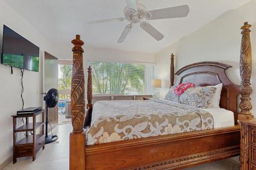 a bedroom with a bed and a ceiling fan at SandPiper #116a in Princeville