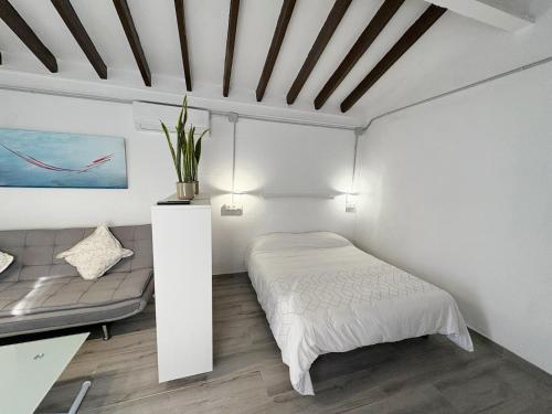 een witte slaapkamer met een bed en een bank bij Beachside Studio in Peaceful Almayate in Almayate Bajo