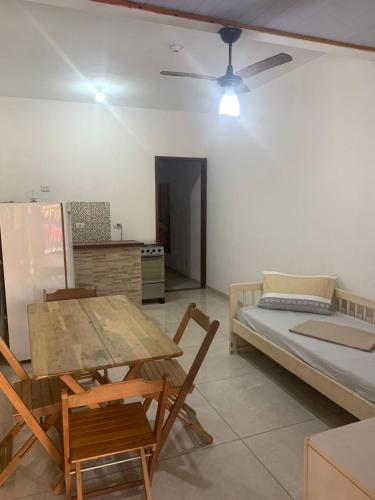a room with a table and chairs and a bed at Casa a 100 metros da praia do Jabaquara in Paraty