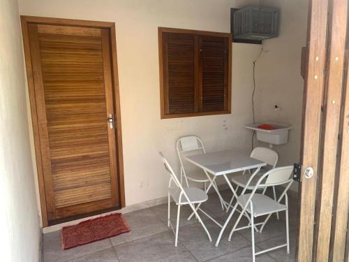 a table and chairs in a room with a door at Casa a 100 metros da praia do Jabaquara in Paraty