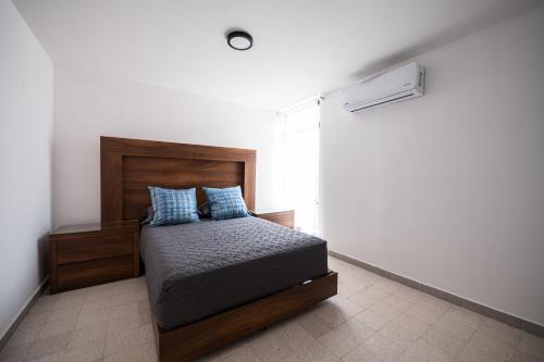 a bedroom with a bed with blue pillows at Residencias Santa Rosa de Viterbo 68 in Casa Blanca La Corregidora